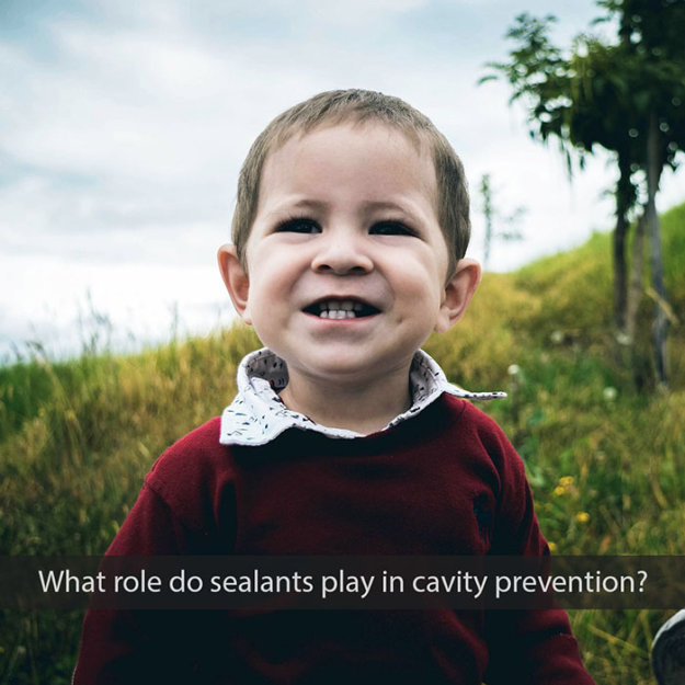 Smiling toddler outdoors in burgundy sweater with text about dental sealants and cavity prevention.