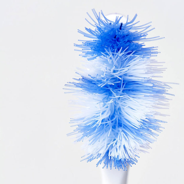 Blue toothbrush bristles fanned out against white background, dental hygiene product.