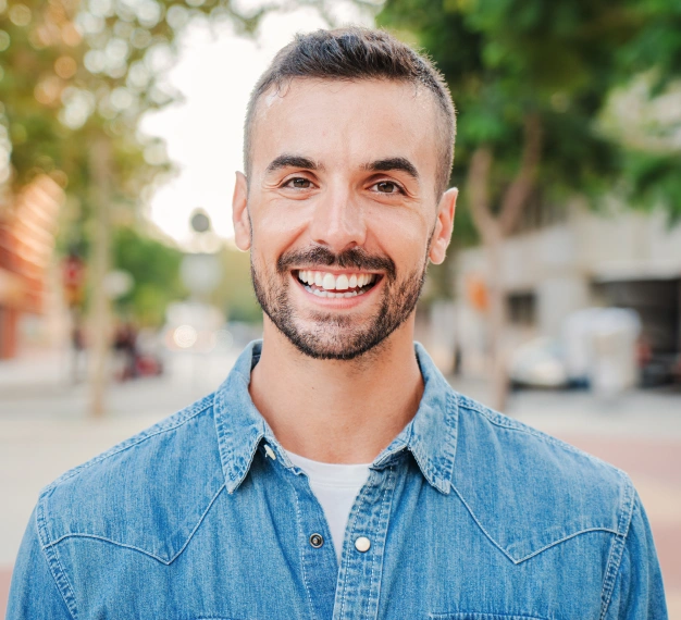 Smiling man with bright white teeth standing outdoors representing professional teeth whitening results at Dentistry of Old Town Scottsdale