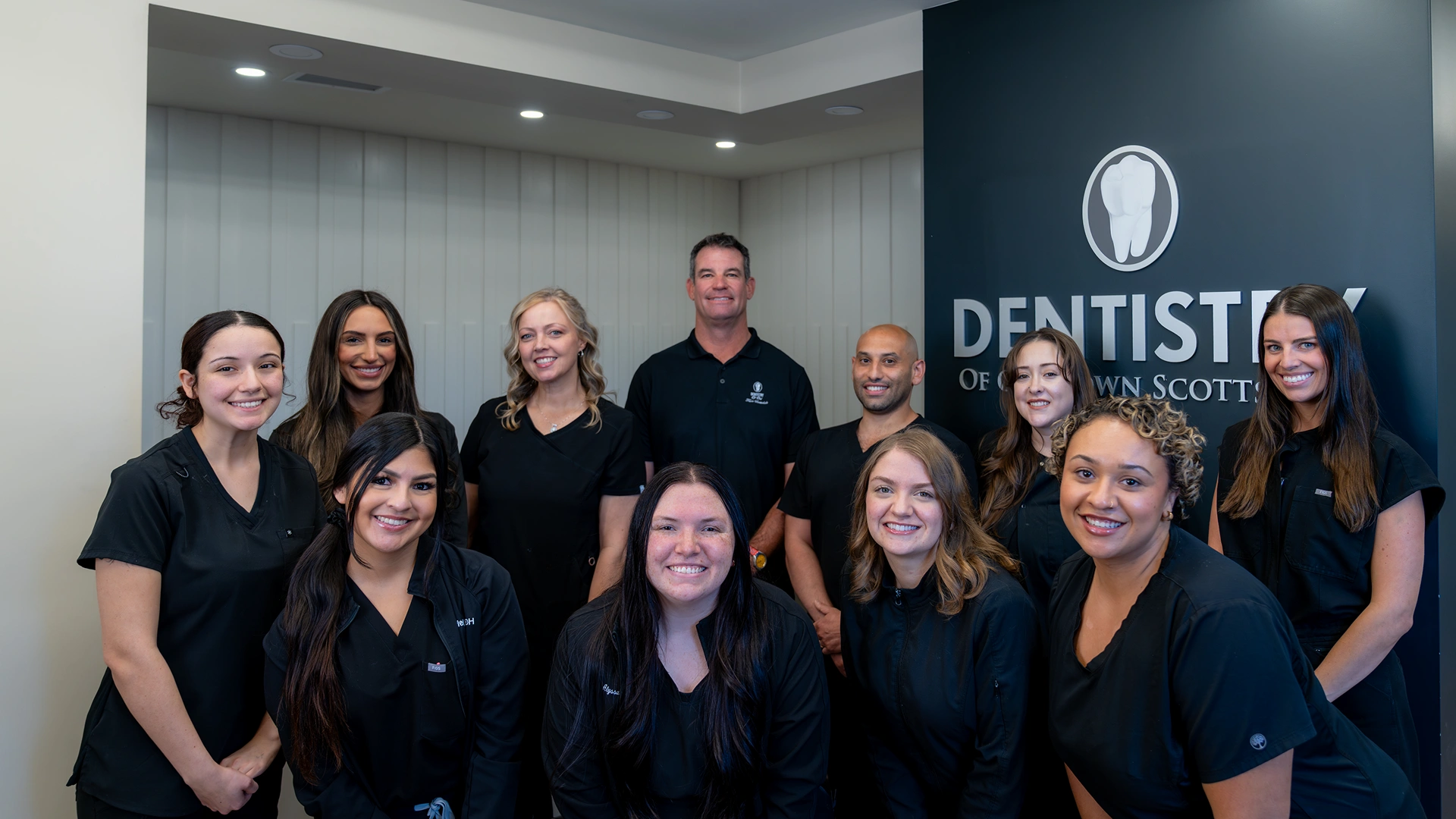 The dental team at Dentistry of Old Town Scottsdale smiling together in a group photo representing the practice team