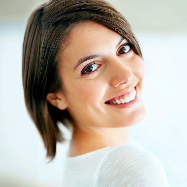 Smiling woman with dark hair representing gum contouring and cosmetic gum reshaping services at Dentistry of Old Town Scottsdale
