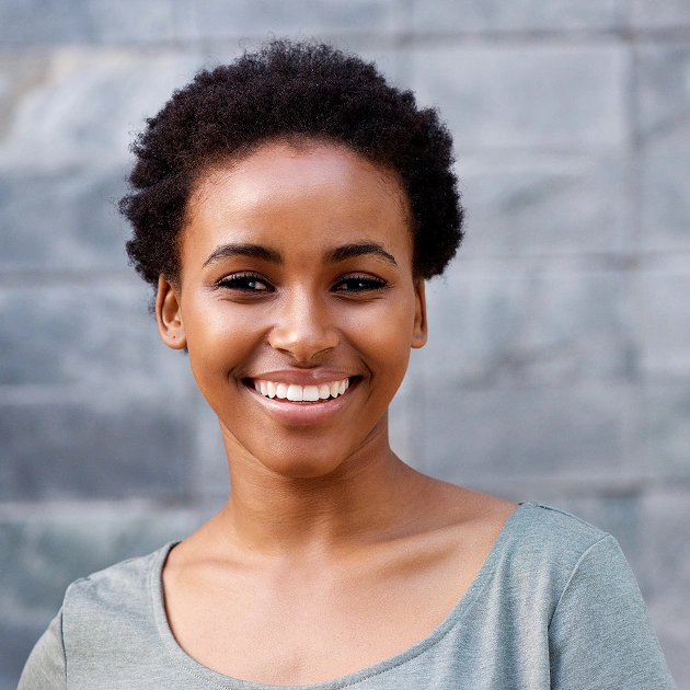 Smiling woman with natural hair representing AcceleDent accelerated orthodontic treatment at Dentistry of Old Town Scottsdale