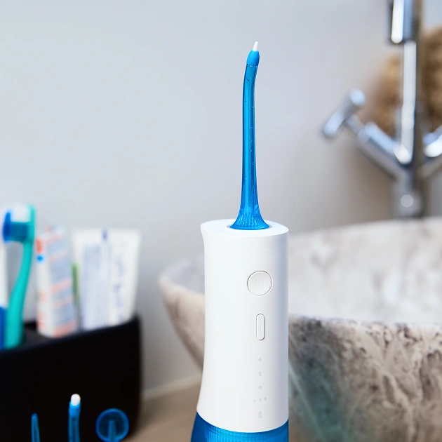 Philips Airfloss device in a bathroom setting representing water flossing tools recommended at Dentistry of Old Town Scottsdale