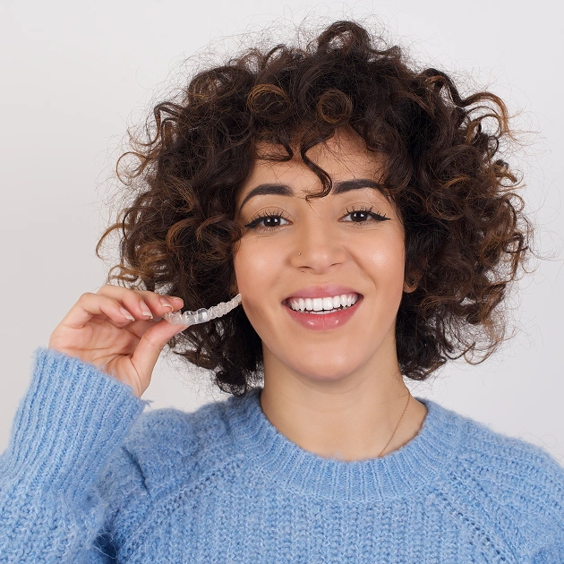 Smiling woman with curly hair representing clear aligner orthodontic treatment at Dentistry of Old Town Scottsdale