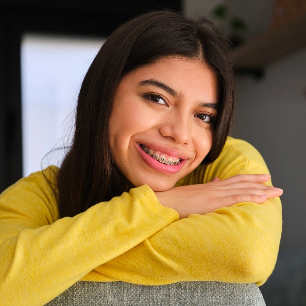 Smiling young woman in a yellow top representing PowerProx Six Month Braces at Dentistry of Old Town Scottsdale