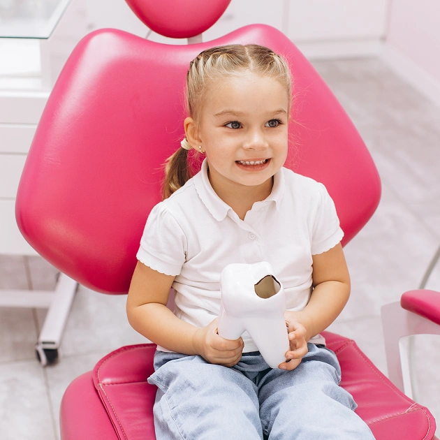 Young girl smiling in a dental chair representing sedation dentistry services for children at Dentistry of Old Town Scottsdale