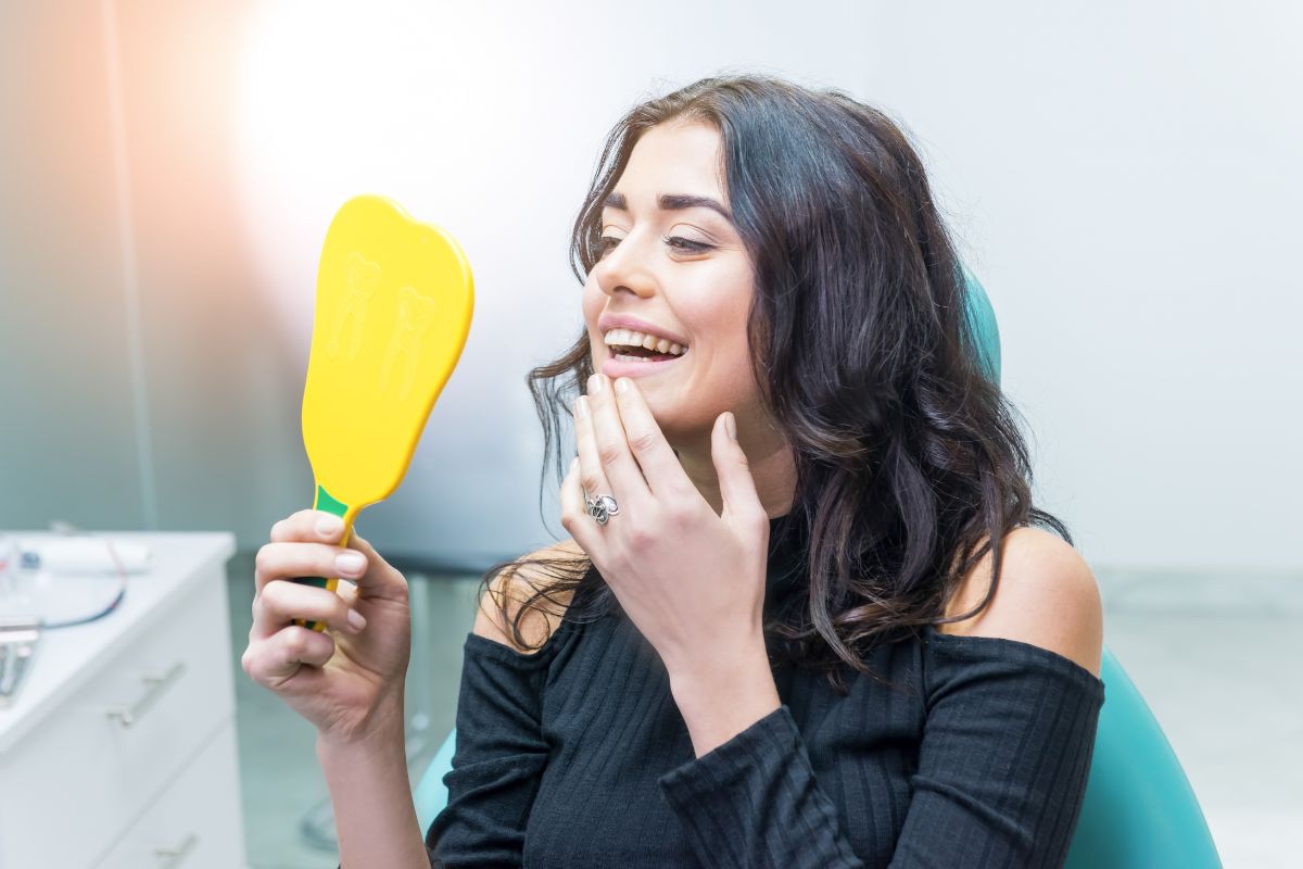 Dentist explaining dental bonding vs veneers treatment options during a cosmetic dentistry consultation.