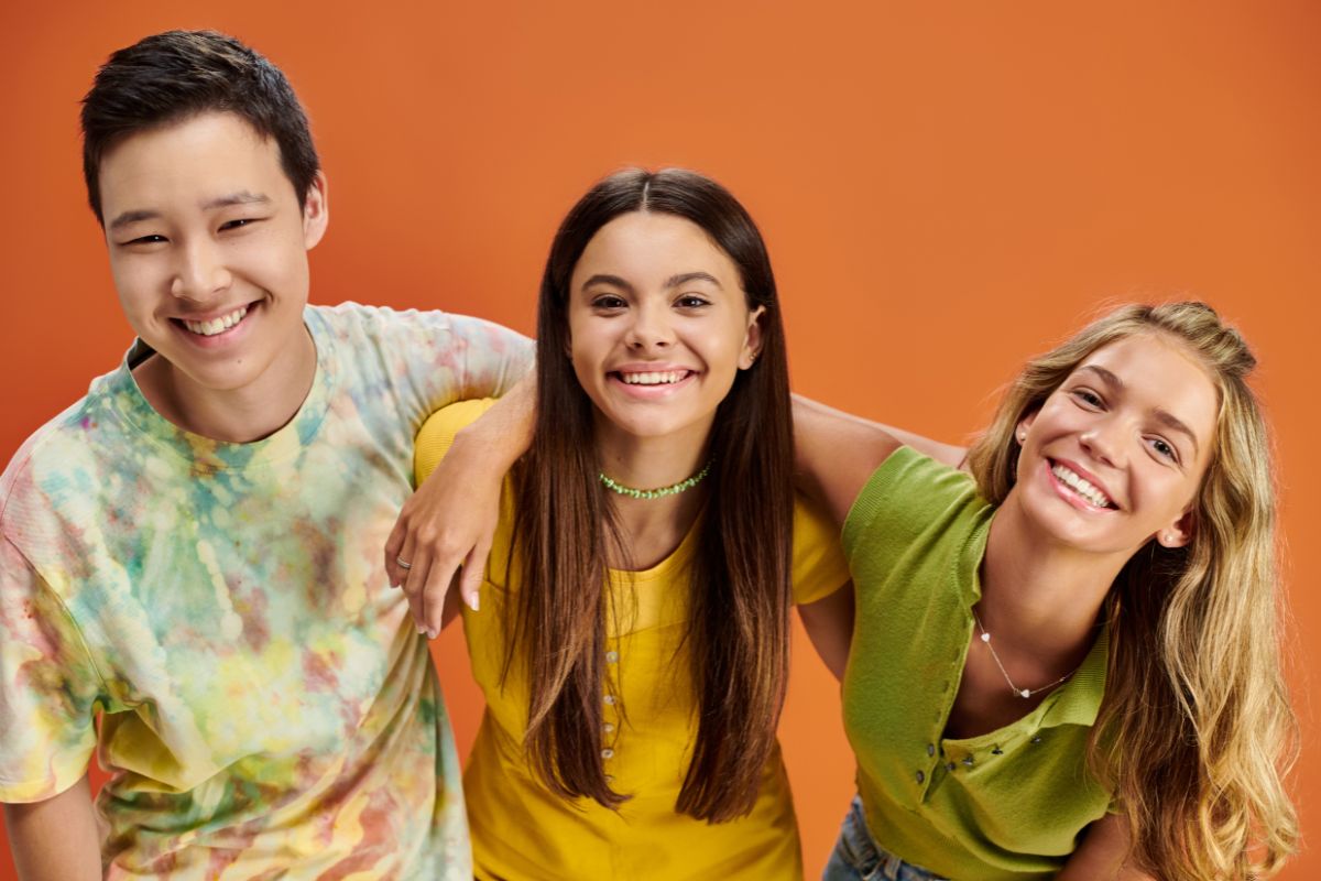 Three smiling teenagers with straight, healthy teeth after Invisalign treatment in Scottsdale